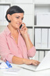 © aletia2011 - Young businesswoman talking on smartphone while working  in office