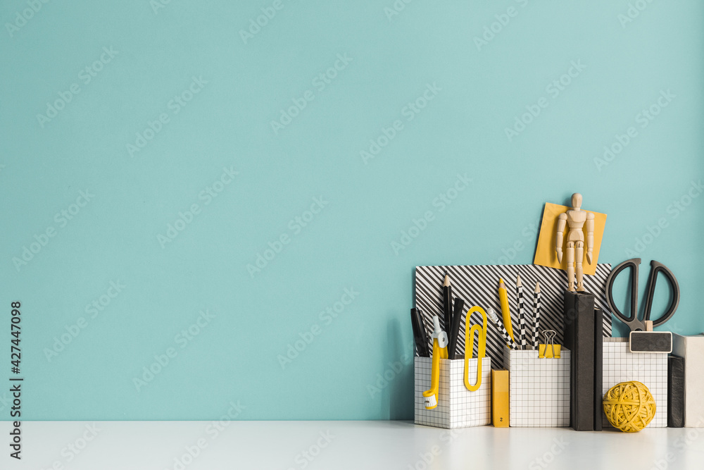 Creative desk with a blank picture frame, desk objects, drawing supplies, pencils, brushes, near bright pastel wall. Artist workspace.	
 - obrazy, fototapety, plakaty 