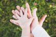 Junge Familie hält Hände zusammen über einer Blumenwiese