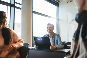 Wall Mural - Student smiling in classroom with laptop