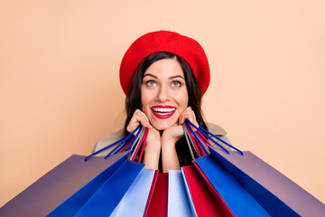 Poster - Photo portrait of adorable girl looking up holding shopping bags isolated on pastel beige colored background