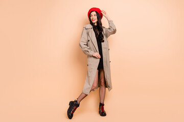 Sticker - Photo portrait full body view of cute girl looking at blank space touching red beret isolated on pastel beige colored background