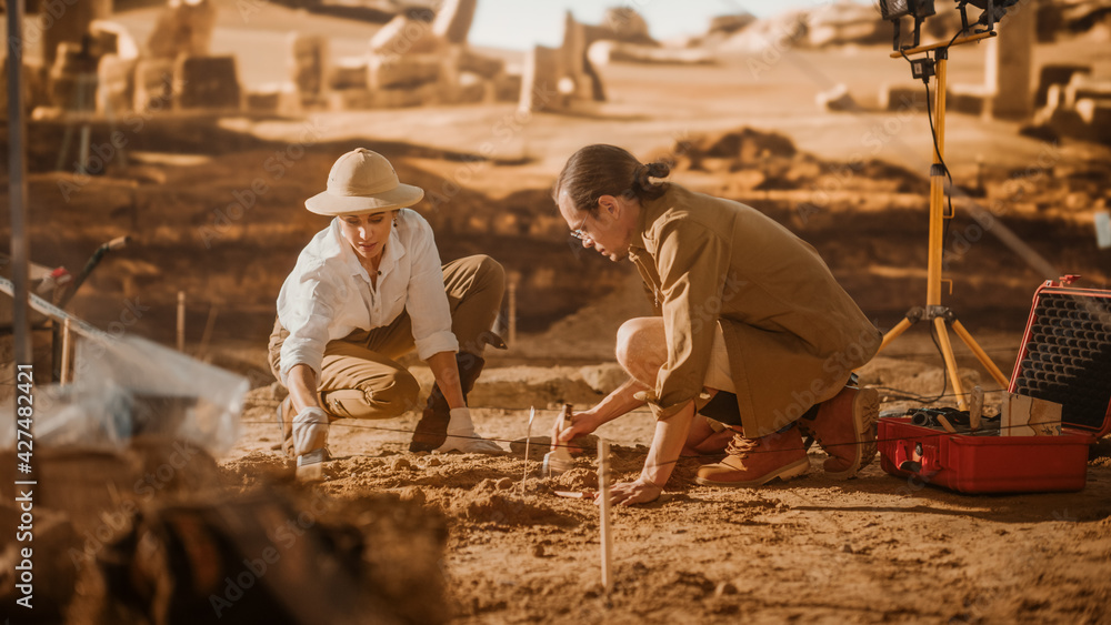 Archaeological Digging Site: Two Great Archeologists Work on Excavation Site, Carefully Cleaning with Brushes and Tools Newly Discovered Ancient Civilization Cultural Artifact, Fossil Remains - obrazy, fototapety, plakaty 