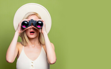 Canvas Print - Beautiful blonde girl in a white hat and dress with binoculars