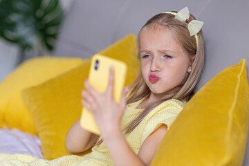 cute little caucasian girl with blonde hair in fashionable dress illuminating yellow color sitting a