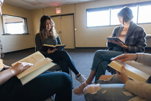 Teen Girls Reading In Circle At Book Club Meeting In Community Center