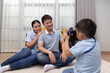 © comzeal - Portrait of happy Asian couple take a pictures by son in living room at home, Little boy photographer and Family relax lifestyle concept