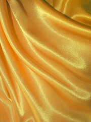 beautiful draped golden silk fabric background. fabric texture