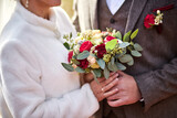 Fototapeta Morze - Bride holding a wedding bouquet in the hands standing near groom
