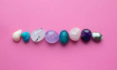 Wall Mural - Gemstone minerals on a pink background. Round tumbling minerals of amethyst, rose quartz, apatite, turquoise, agate.