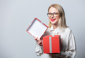 Wall Mural - Portrait of beautiful blonde in white shirt with gift box on white background