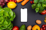 Telefon z białym ekranem i miejscem na tekst, otoczony warzywami i owocami, zdrowa dieta i odżywianie