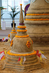 Wall Mural - Close up a sand pagoda surrounded with yellow flowers on sand floor