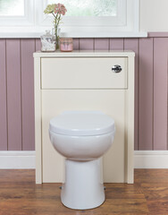 Poster - Vertical shot of a toilet with cabinet in a bathroom