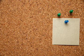 Canvas Print - Closeup shot of three pins and an empty white paper with space for text on a corkboard