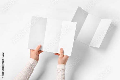 Obraz Dibond Hands with blank brochures on light background