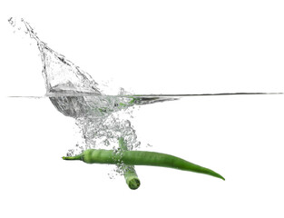 Falling of fresh chili peppers into water against white background