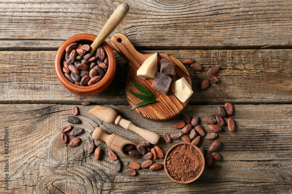 Composition with cocoa beans on wooden background