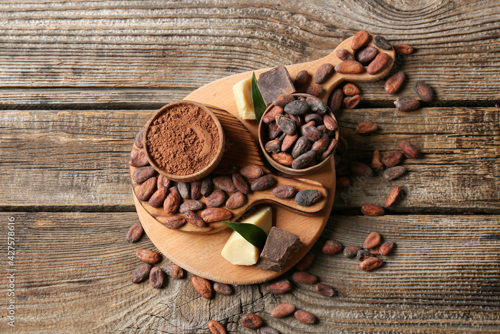 Composition with cocoa beans on wooden background
