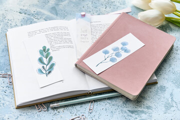 Wall Mural - Book with bookmarks, notebook and flowers on color background