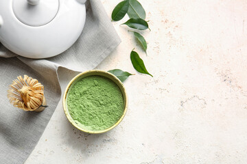 Bowl with powdered matcha tea, teapot and chasen on light background