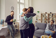 © Studio Romantic - I'm so happy for you: African American woman embracing young Caucasian man and smiling. It's good to see you again: Two excited cheerful friends hug each other as they meet at a reunion party