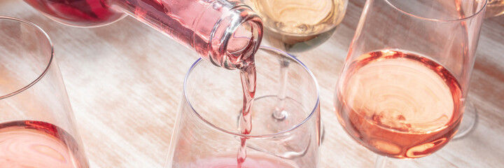 Rose wine pouring panorama with various glasses