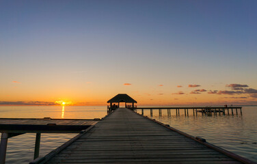 Wooden pier leading hut on indian ocean in the Maldives at sunset.Beautiful sky and clouds and beach background for summer vacation holiday and travel concept 