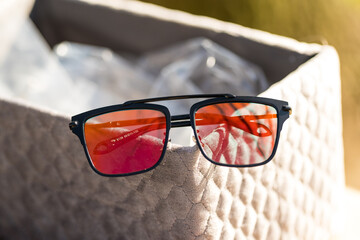 Wall Mural - Futuristic sunglasses design with big red flat lenses closeup shoot outside in a summer day . Selective focus. High quality photo