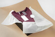 © Юля Бурмистрова - blank tag for size, logo, instructions on burgundy sweater in black box and white tissue paper on beige craft paper.
