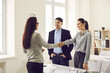 © Studio Romantic - Happy married couple enters into an agreement with a bank employee by taking a loan or mortgage from a bank. Female banking agent shakes hands with customers congratulating new homeowners.