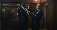 Cinematic Shot Of Professional Tailor Taking Measurements For Creation Of Custom High Quality Tailored Suit In Luxury Tailoring Atelier.Concept Of Fashion, Handmade, Hand Craft, Couturier And Business