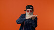 Mature old bearded grandfather in sunglasses and cap showing wasting or throwing money around hand gesture, more tips dreaming about big profit body language. Senior man isolated on orange background