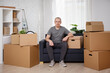 © Di Studio - moving day concept - happy man sitting on sofa in room