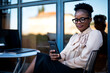 © JustLife - Businesswoman using the phone in cafe. African woman on coffee break.