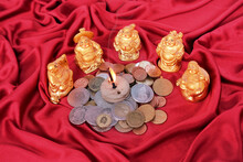 Slide Of Metal Coins, Currencies Of Different Countries, Figurines Of Japanese Hotei God Of Wealth, Incense Stick Is Burning, Symbol Of Fun, Prosperity, Concept Of Multiplying And Saving Money