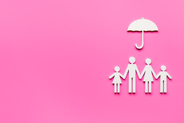 Wall Mural - Wooden family figure under umbrella with space for text. Insurance concept