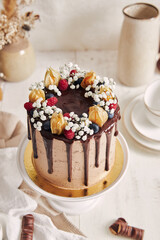 Poster - High angle shot of a beautiful chocolate cake decorated with berries and flowers