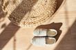 textile moccasins made of natural fabric against the background of a wicker rattan ottoman. Flatlay