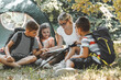 © BalanceFormCreative - Group of school kids sitting on grass in forest with they teacher.They learning about nature and wildlife.