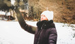 Młoda kobieta bawiąca się śniegiem na świeżym powietrzu w zimie