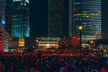 Crowd Of People By Illuminated Building At Night