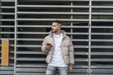 Sexy male in a street style outfit posing outdoors