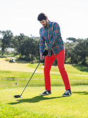 Wall Mural - Young Caucasian male playing golf on a professional golf course