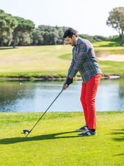 Canvas Print - Young Caucasian male playing golf on a professional golf course