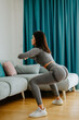 © shevtsovy - butt workout at home squats. Attractive Woman with strong butt workout at home. Female gymnastics. Glutes workout motivation.