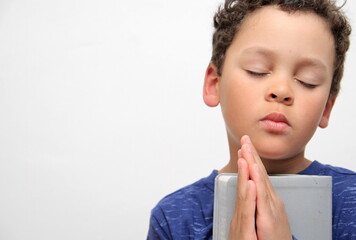 Wall Mural - boy praying to God with hands together on white background stock photo