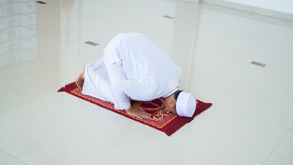 A portrait of an asian muslim man pray at mosque, the pray name is sholat, sujud movement on sholat