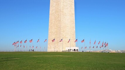 Wall Mural - Flags of the United States near washington monument waving over blue sky