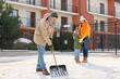 Family removing snow outdoors on winter day